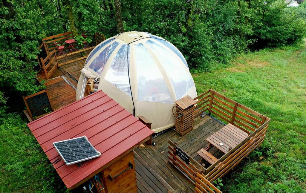 un parasol et une table avec un ordinateur portable sur une terrasse dans l'établissement Le Mobil'Dôme à Marie, à Cambounès