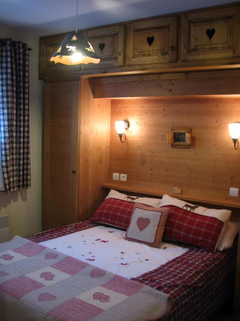 une chambre avec un grand lit avec une tête de lit en bois dans l'établissement Appt Le Hameau Des Rennes 4 étoiles Pieds des pistes Piscine Intérieure Extérieure, à Vars