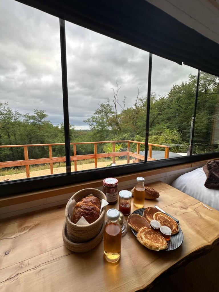 - une table avec du pain, des boissons et un panier de nourriture dans l'établissement Hébergement insolite avec vue imprenable, à Lafrançaise