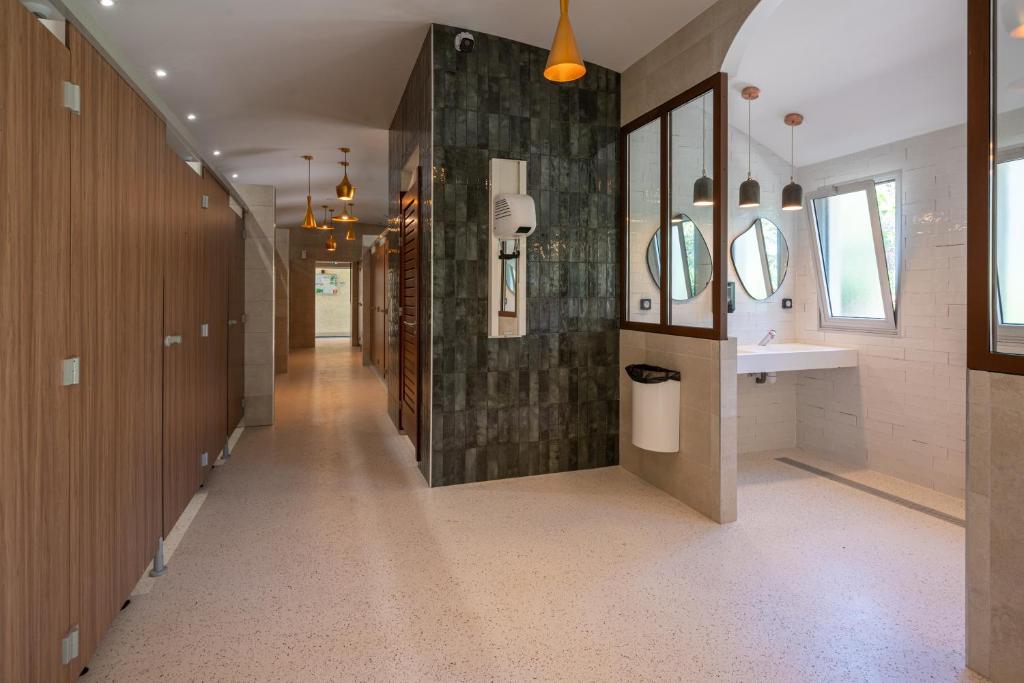 - un couloir d'une salle de bains pourvue d'un lavabo et de miroirs dans l'établissement Camping RCN Domaine de la Noguière, au Muy