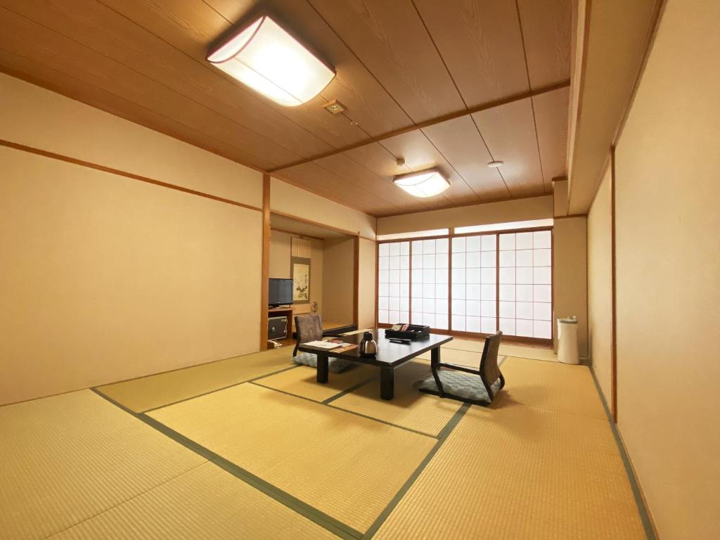 une grande pièce avec une table et des chaises dans l'établissement Hotel Kusakabe Armeria, à Gero