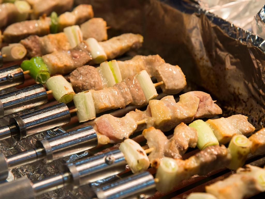 Un tas de nourriture est en train de cuisiner sur un grill. dans l'établissement Hotel Kusakabe Armeria, à Gero