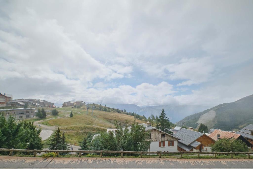 - une vue sur un village avec une montagne dans l'établissement appartement duplex, à Huez