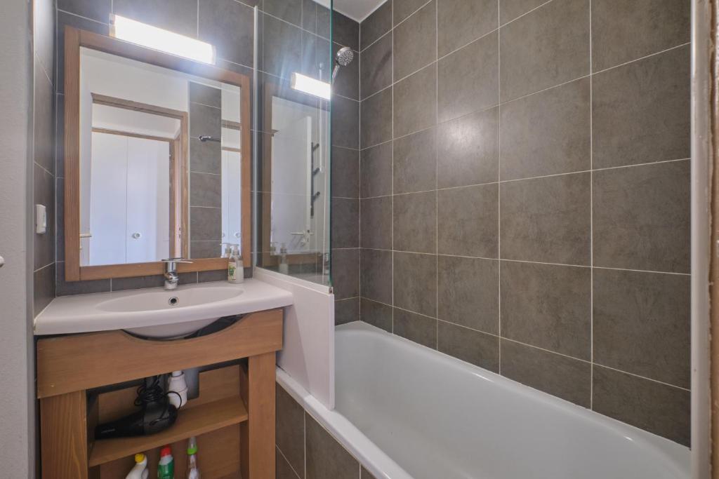 une salle de bain avec un lavabo et une baignoire dans l'établissement appartement duplex, à Huez 12 autres photos