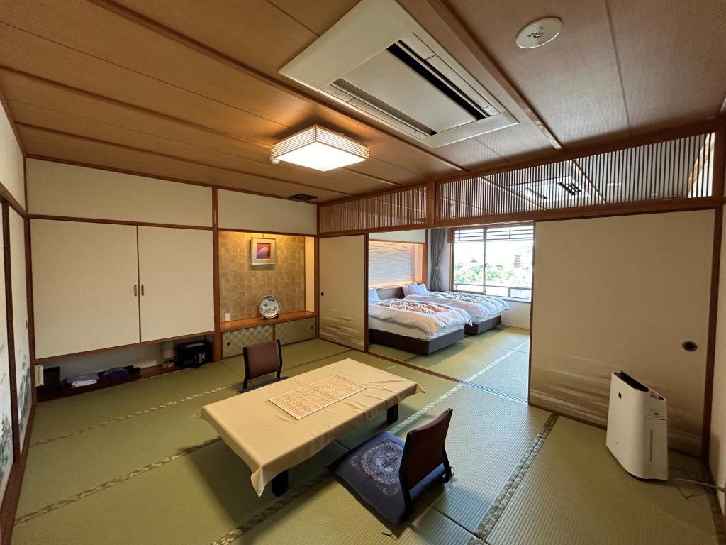 une chambre avec un lit, une table et des chaises dans l'établissement Jukeiso, à Miyajima 37 autres photos