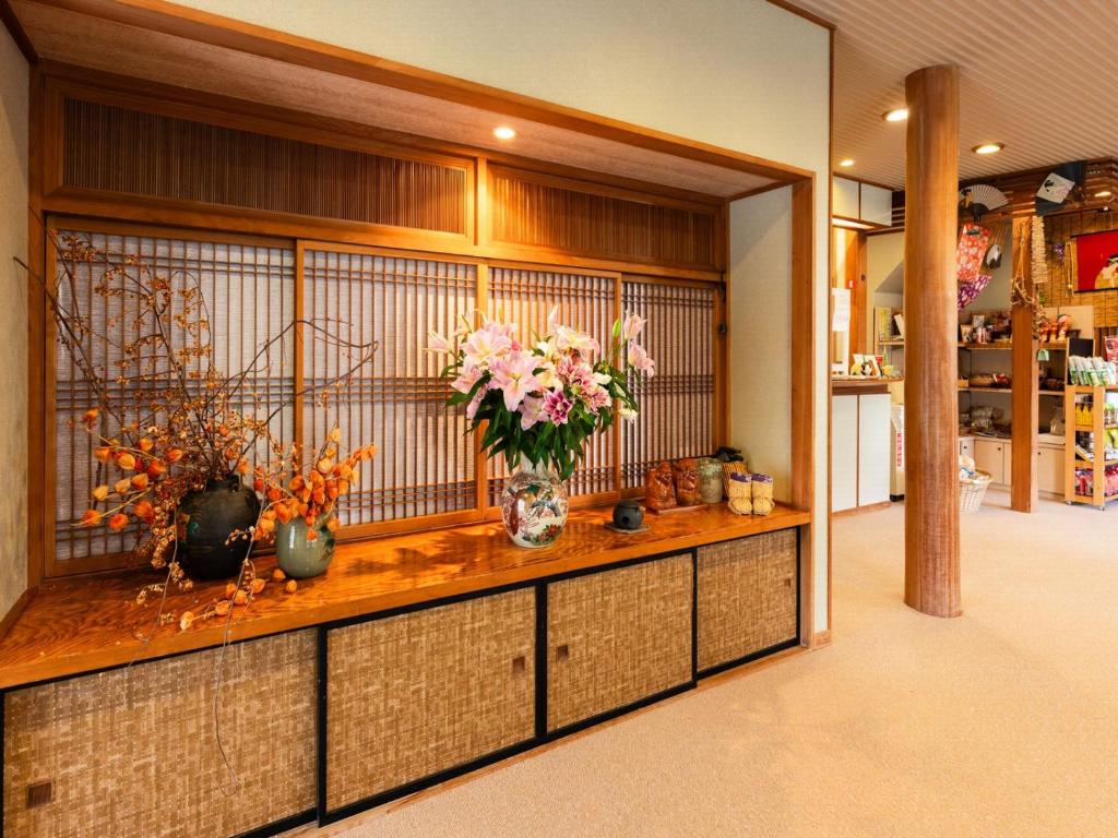 une pièce avec un comptoir avec des vases de fleurs dessus dans l'établissement Otowaya Ryokan, à Yuzawa