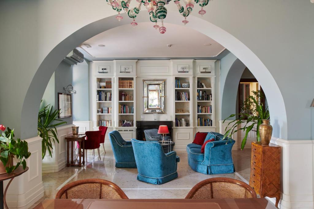 une voûte dans un salon avec des chaises et une cheminée dans l'établissement Hotel Riviera & Maximilian's, à Trieste