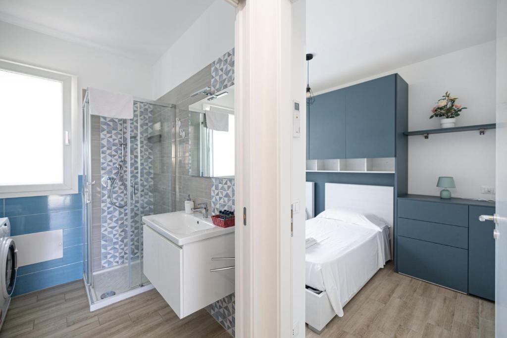 La salle de bains est pourvue d'un lavabo blanc et de placards bleus. dans l'établissement Villa Portofino, à Campofelice di Roccella