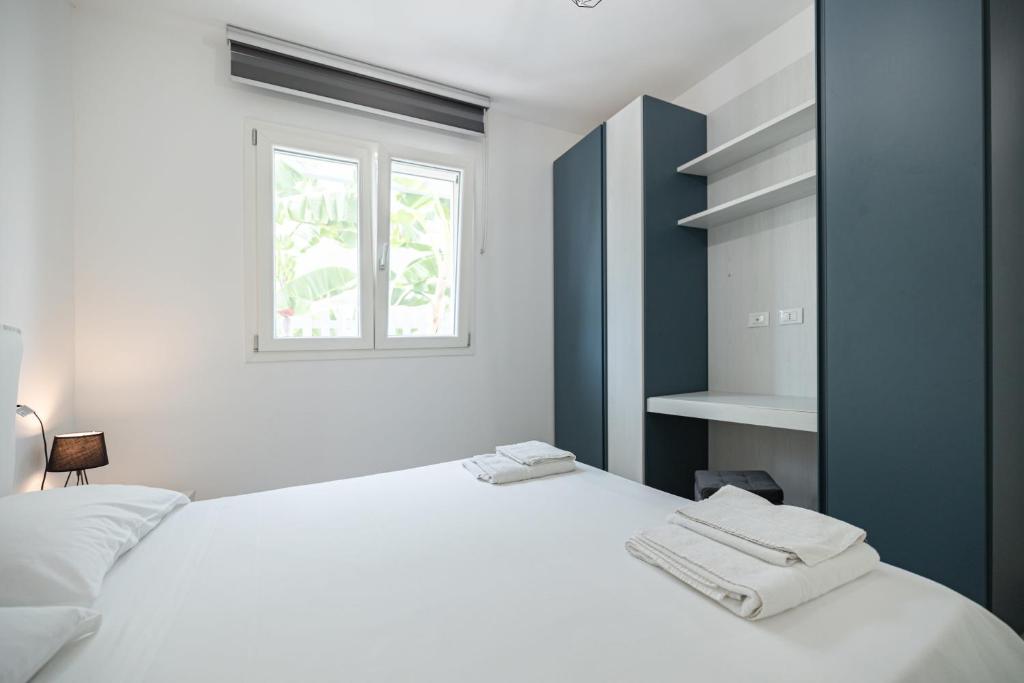 une chambre blanche avec un lit blanc et une fenêtre dans l'établissement Villa Portofino, à Campofelice di Roccella