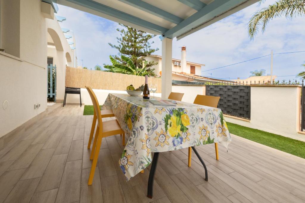 une table et des chaises sur le patio d'une maison dans l'établissement Villa Portofino, à Campofelice di Roccella
