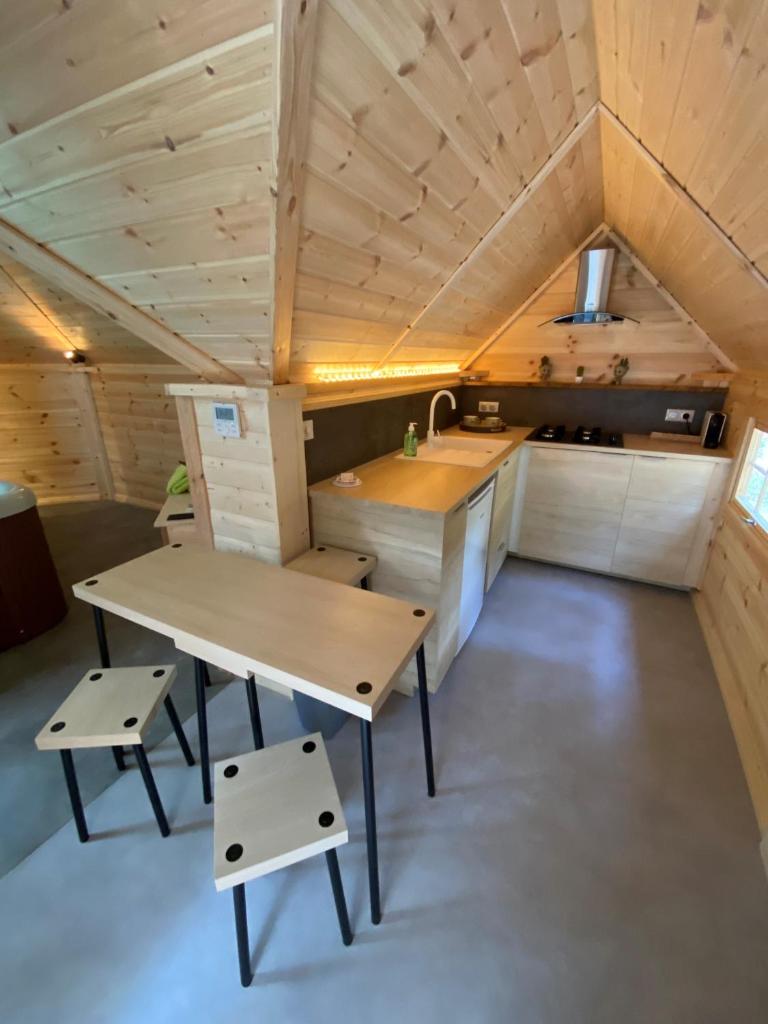 - une cuisine avec une table et des bancs dans une pièce dans l'établissement Les hebergements Insolites, à Taradeau