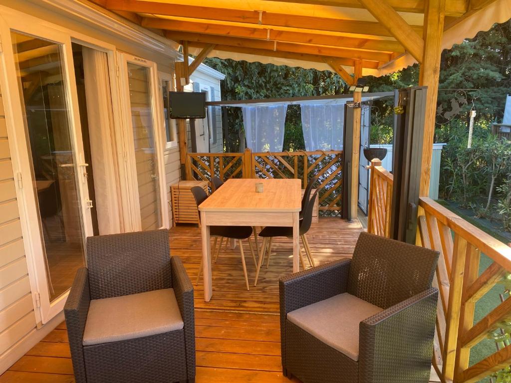un patio avec une table et des chaises sur une terrasse dans l'établissement Oasis de détente, à Fréjus