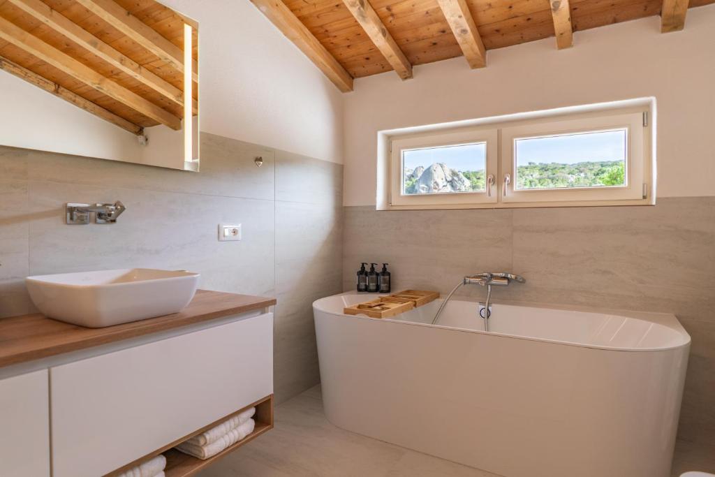 une salle de bain avec une baignoire blanche et un lavabo dans l'établissement Villa Gerani Luxus mit Meerblick, à Porto Rafael