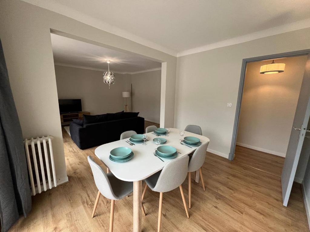 un salon avec une table et des chaises blanches dans l'établissement Les Balcons du Couloubret, à Ax-les-Thermes