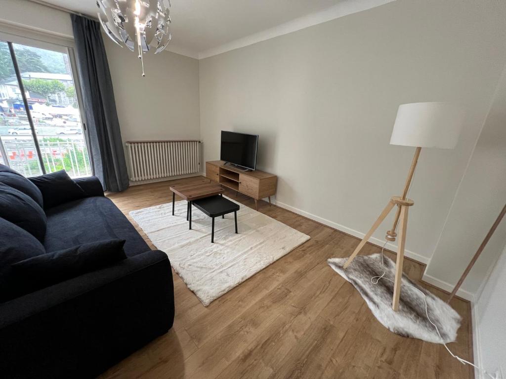 un salon avec un canapé et une table dans l'établissement Les Balcons du Couloubret, à Ax-les-Thermes