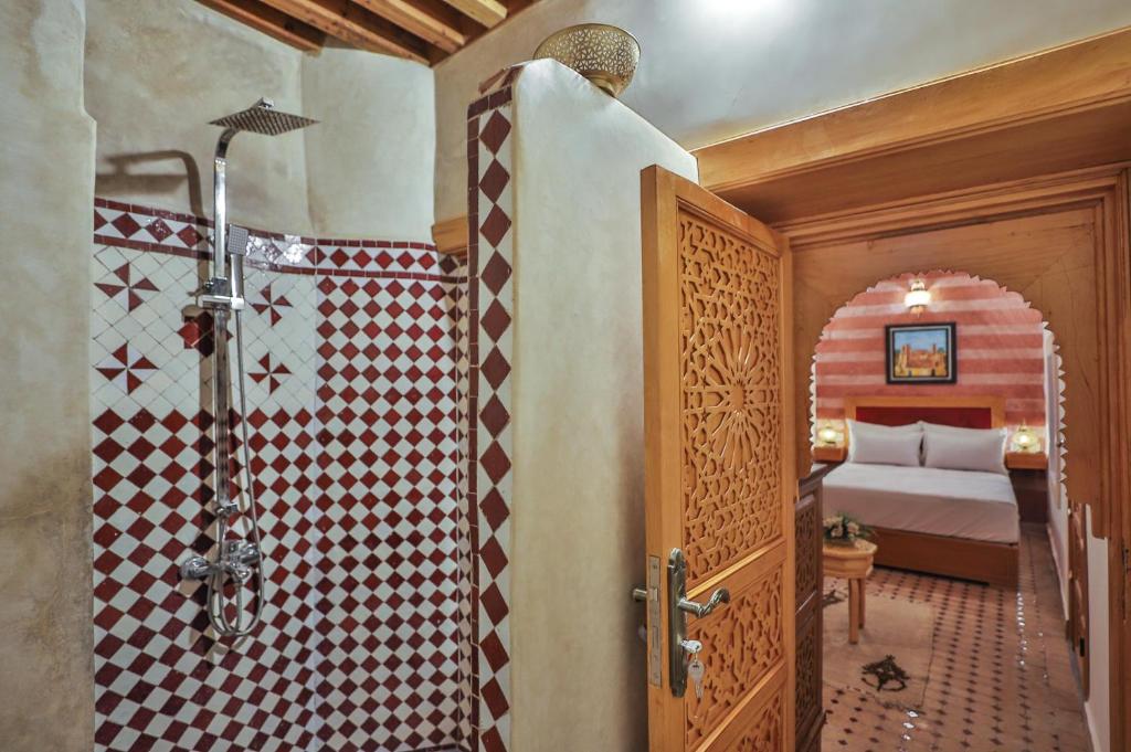 une salle de bain avec douche et une chambre avec un lit dans l'établissement Riad Ridaya, à Fès