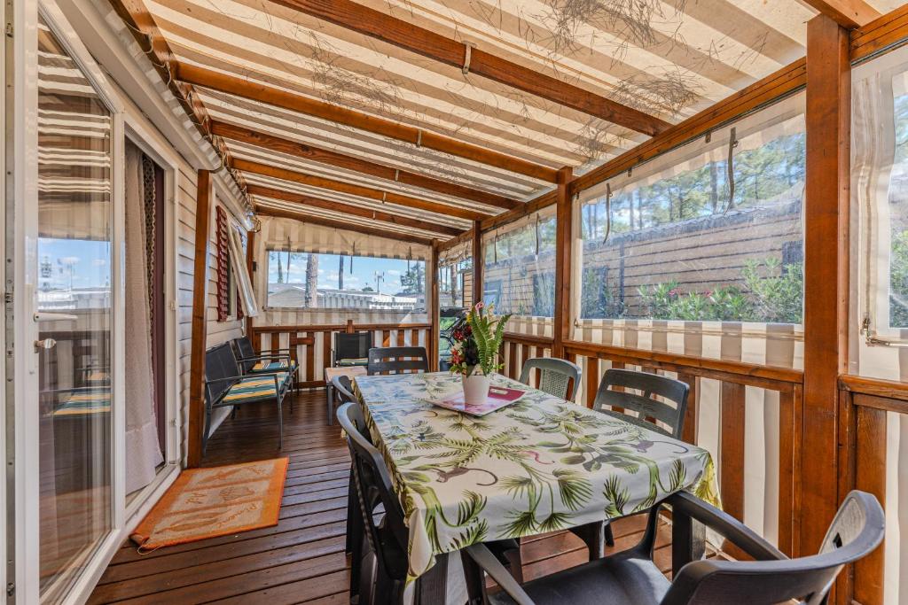 une salle à manger avec une table et des chaises sur un balcon dans l'établissement les dunes de contis, à Saint-Julien-en-Born