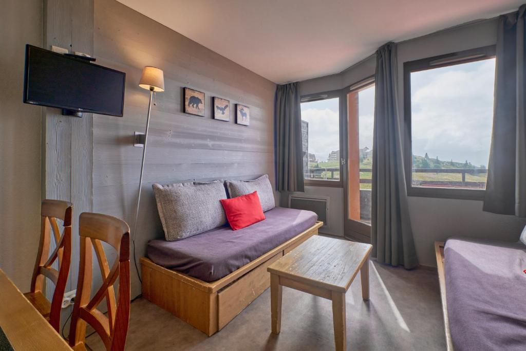 - un petit salon avec un canapé et une fenêtre dans l'établissement appartement duplex, à Huez