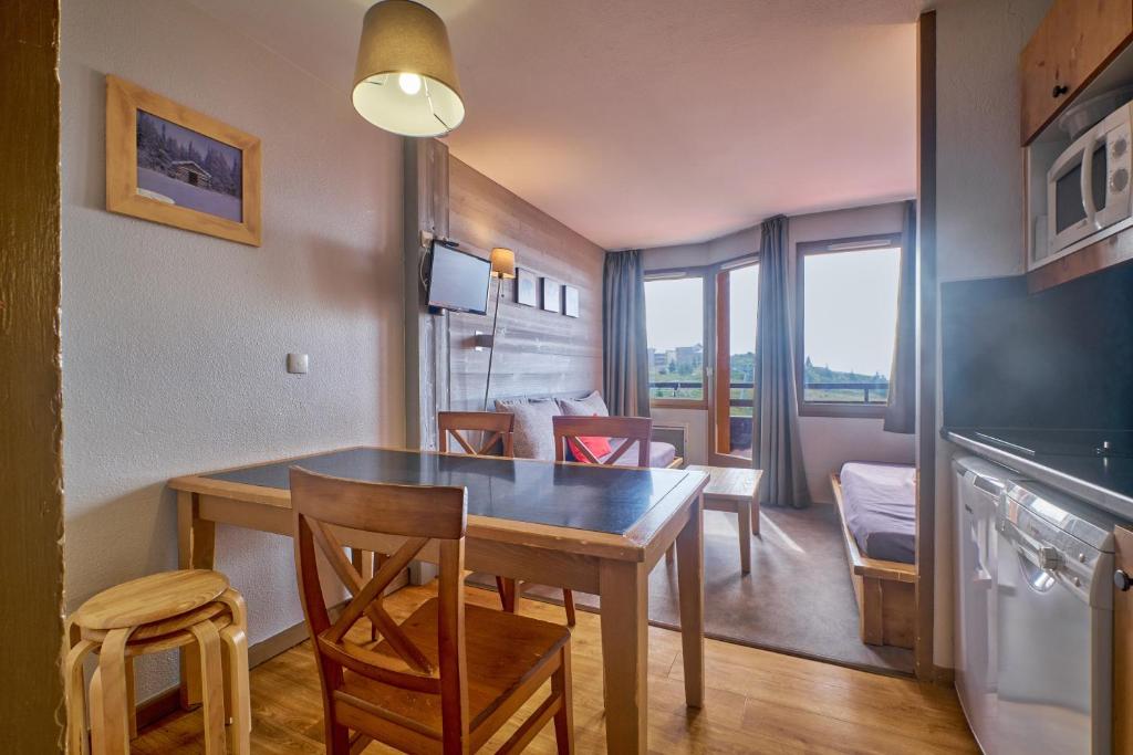 une cuisine et une salle à manger avec une table et des chaises dans l'établissement appartement duplex, à Huez