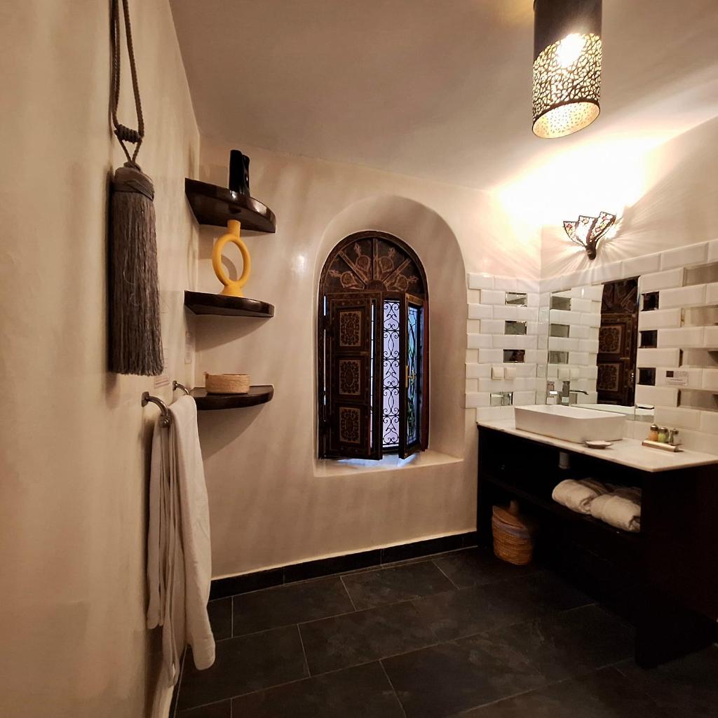 une salle de bain avec un lavabo et une fenêtre dans l'établissement Riad El Grably, à Marrakech