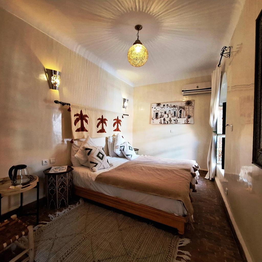 une chambre avec un grand lit dans une pièce dans l'établissement Riad El Grably, à Marrakech