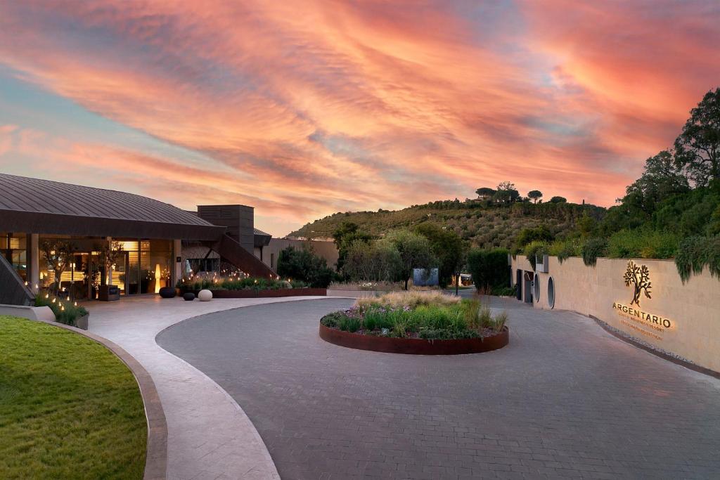 un coucher de soleil sur un bâtiment avec un ciel nuageux dans l'établissement Argentario Golf & Wellness Resort, Autograph Collection, à Porto Ercole