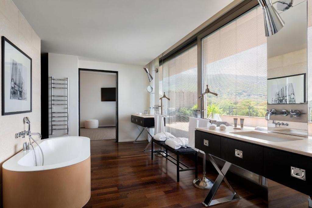 une salle de bain avec une baignoire et deux lavabos et une grande fenêtre dans l'établissement Argentario Golf & Wellness Resort, Autograph Collection, à Porto Ercole