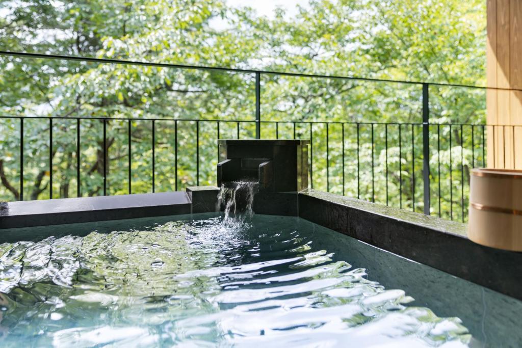 un bassin profond avec une fontaine dans l'établissement Laforet Shuzenji Sanshisuimei, à Izu