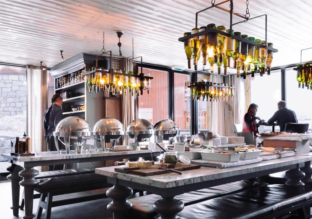 un restaurant avec une table avec de la nourriture dessus dans l'établissement Langley Hôtel Tango, à Val Thorens