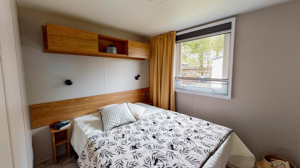 une petite chambre avec un lit et une fenêtre dans l'établissement Camping Officiel Siblu La Pointe, à Capbreton 24 autres photos