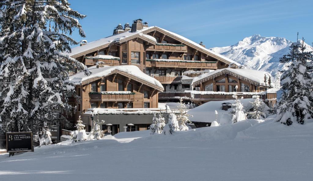 un lodge de ski dans la neige avec des arbres enneigés dans l'établissement Hôtel Barrière Les Neiges Courchevel, à Courchevel