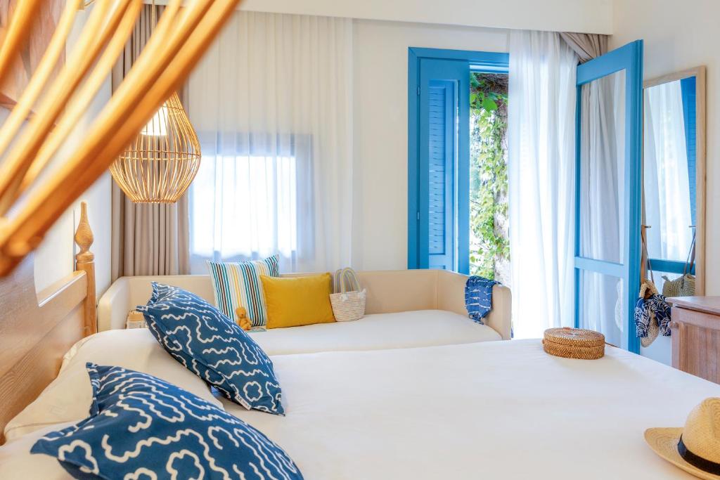 une chambre avec un lit avec des oreillers bleus et blancs dans l'établissement MClub Budoni, à Budoni 67 autres photos