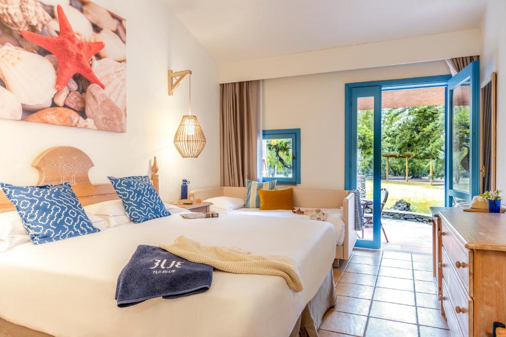 une chambre d'hôtel avec un grand lit et une cuisine dans l'établissement MClub Budoni, à Budoni