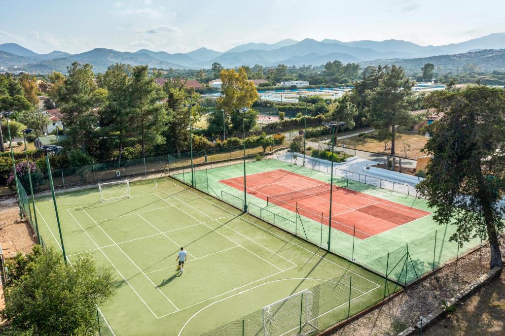 un homme jouant au tennis sur un court de tennis dans l'établissement MClub Budoni, à Budoni