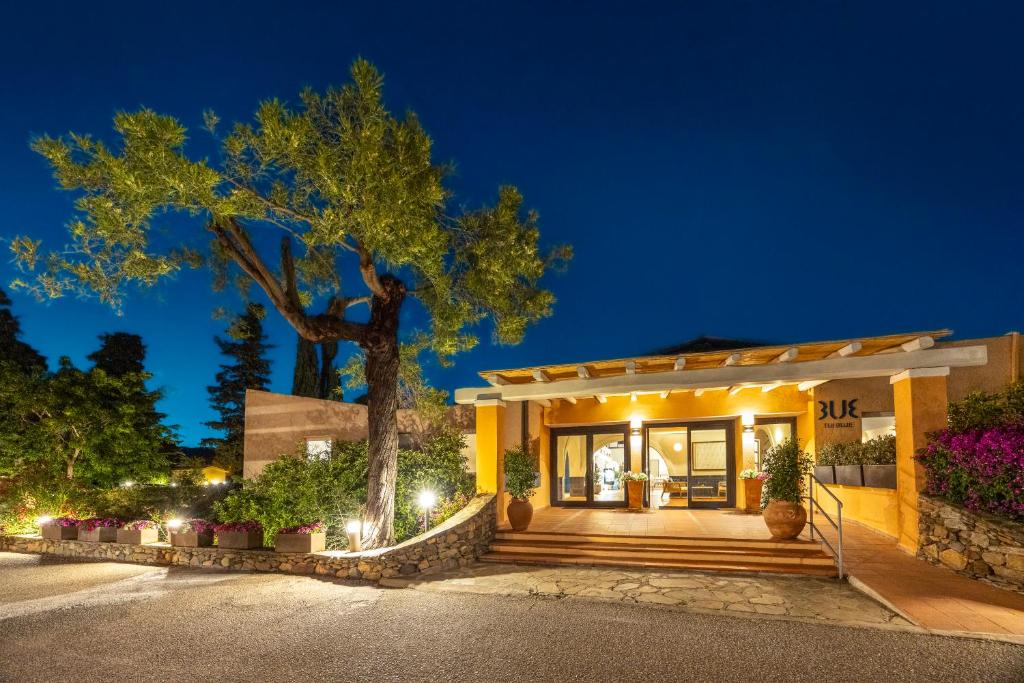 une maison avec un arbre devant un bâtiment dans l'établissement MClub Budoni, à Budoni