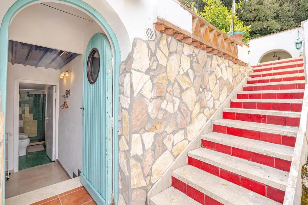 un escalier avec un mur en pierre et une porte bleue dans l'établissement Villa Mariani - Italian Coastal Charm, à San Felice Circeo