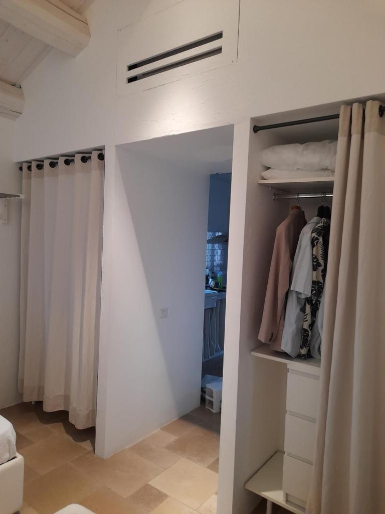 une chambre avec un placard blanc avec un rideau dans l'établissement Villa Poggio Fiorito, à Corato