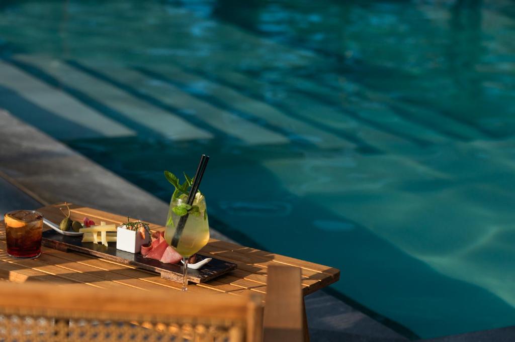 - une boisson assise sur une table à côté d'une piscine dans l'établissement Q Resort, à Marina di Sorso