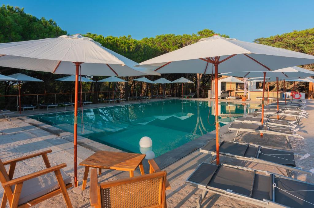 une piscine avec chaises et parasols dans l'établissement Q Resort, à Marina di Sorso