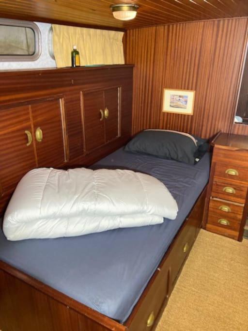 - un petit lit dans un bateau avec cabine en bois dans l'établissement Bateau, à Marseilles-lès-Aubigny