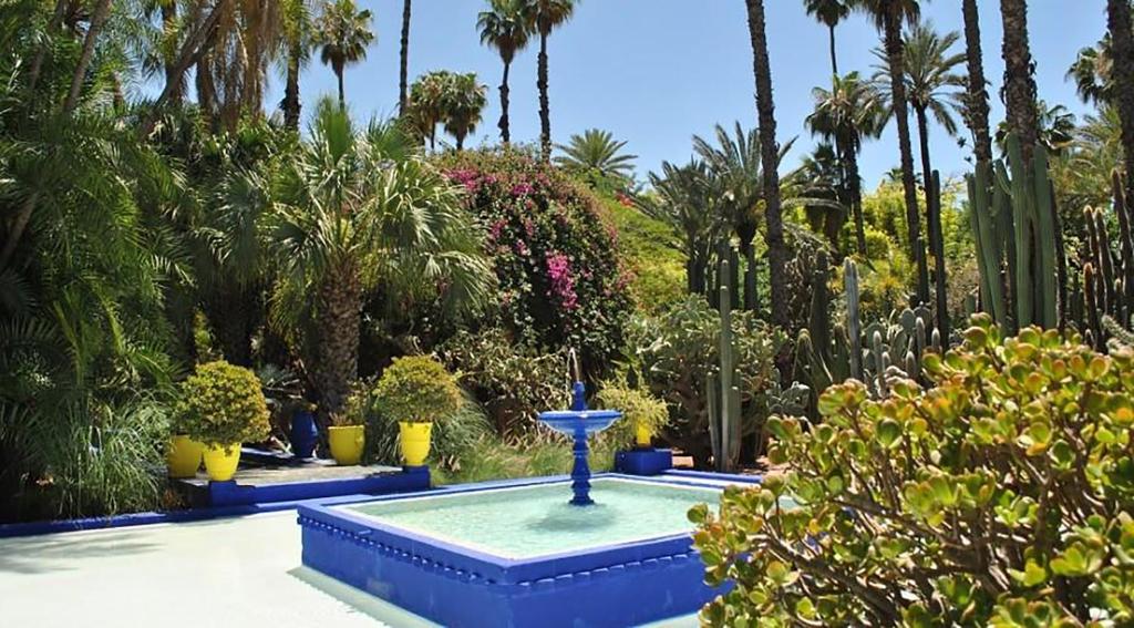 une fontaine au milieu d'un jardin planté de palmiers dans l'établissement Riad K, à Marrakech