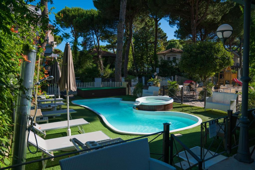 une piscine avec deux chaises et un parasol dans l'établissement Hotel Europa Milano Marittima, à Milano Marittima