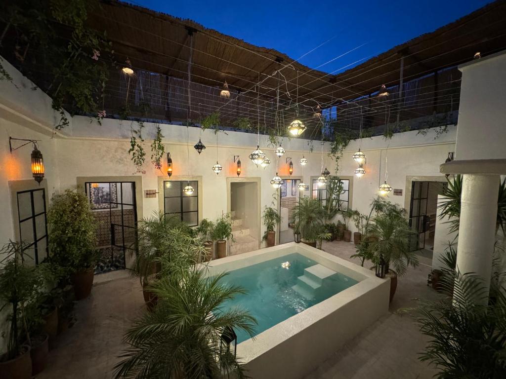 - une piscine au milieu d'un immeuble avec des plantes dans l'établissement Riad Ait El Mouden, à Agadir