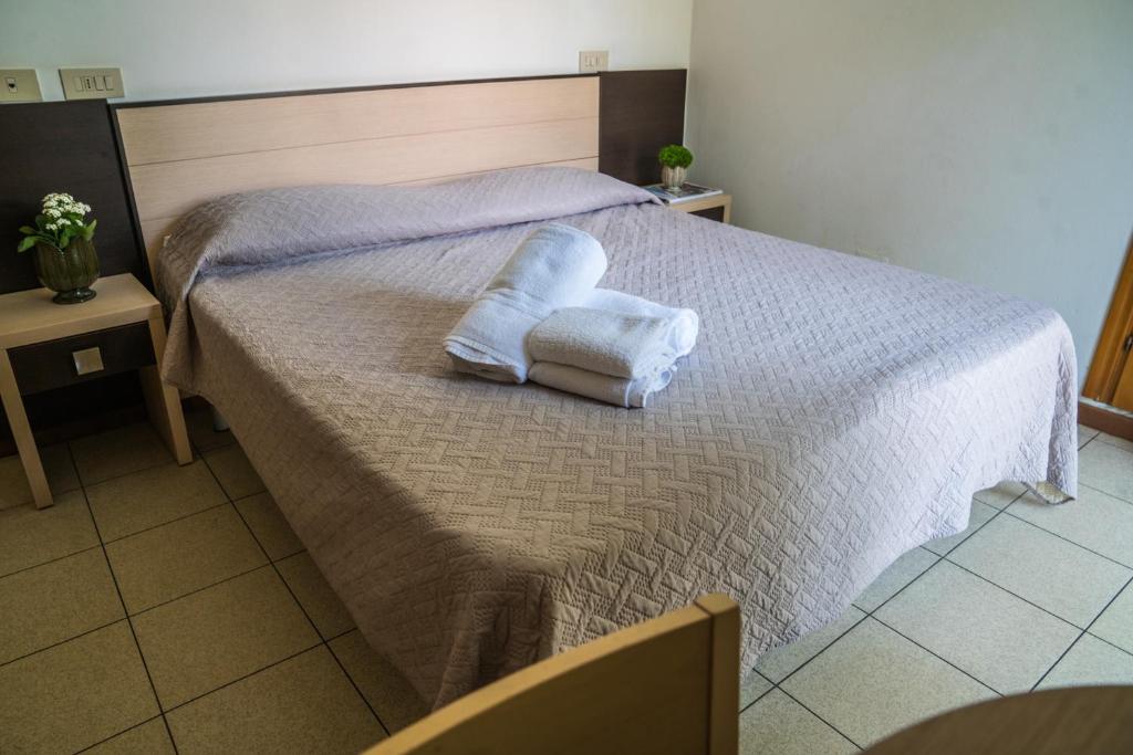 une chambre avec un lit avec deux serviettes dessus dans l'établissement Hotel Europa Milano Marittima, à Milano Marittima