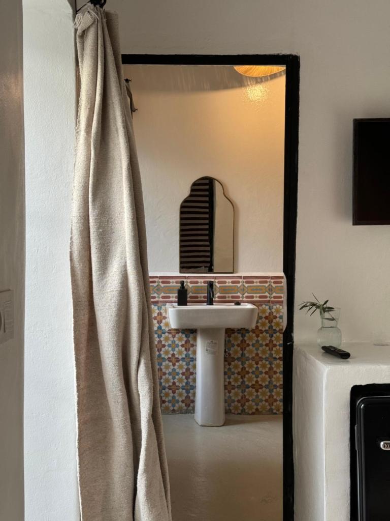 une salle de bain avec un lavabo et un rideau de douche dans l'établissement Riad Ait El Mouden, à Agadir
