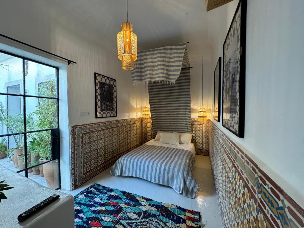 une chambre avec un lit dans une pièce avec une fenêtre dans l'établissement Riad Ait El Mouden, à Agadir