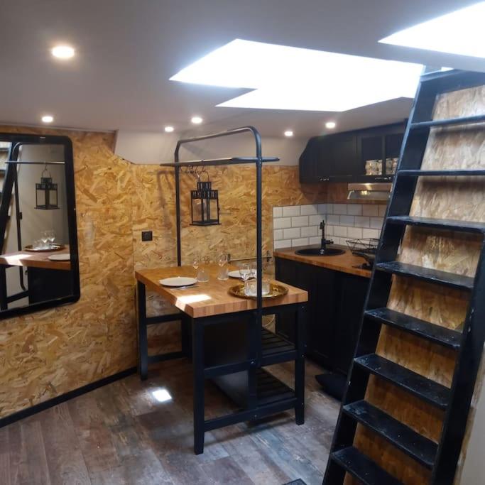 - une cuisine avec une table en bois dans une chambre dans l'établissement Péniche Chaleureuse avec jacuzzi Toulouse centre, à Toulouse
