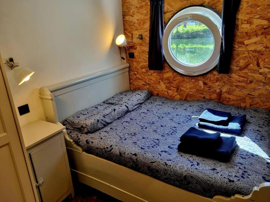 - une petite chambre avec un lit et une fenêtre dans l'établissement Péniche Chaleureuse avec jacuzzi Toulouse centre, à Toulouse