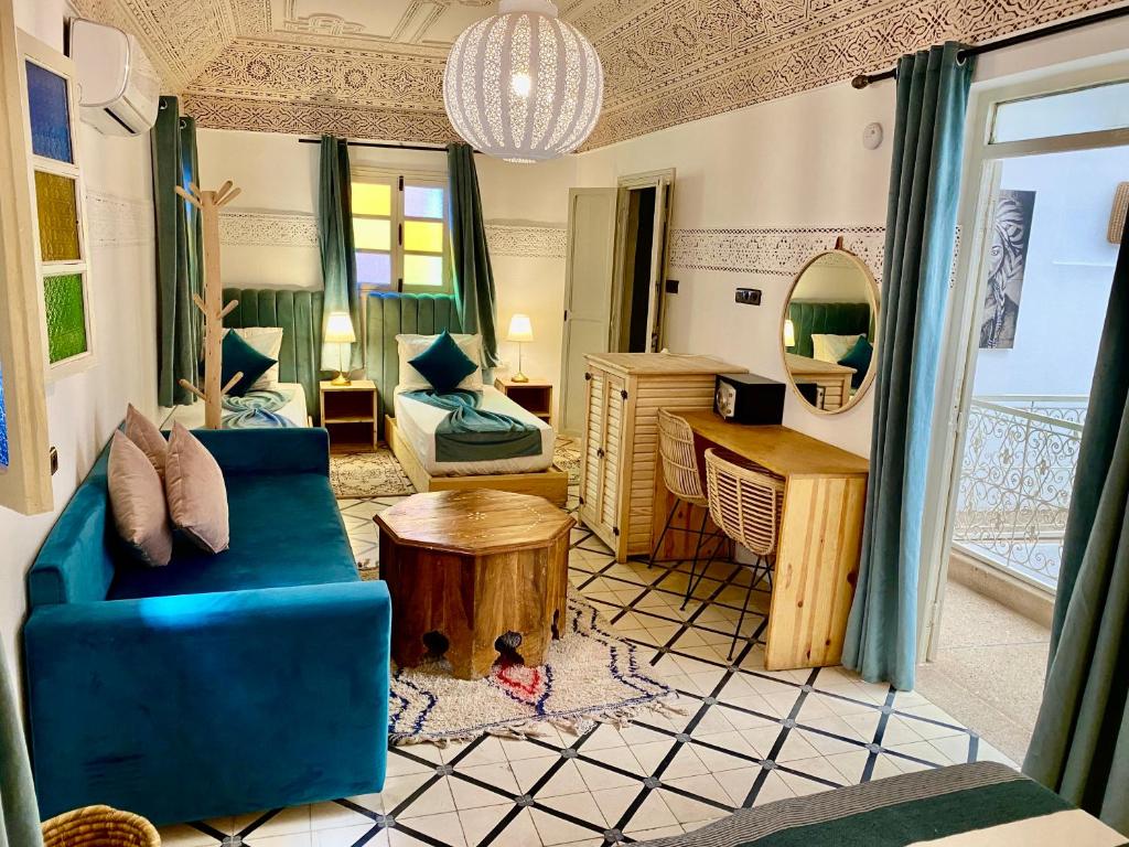 un salon avec un canapé bleu et une table dans l'établissement Riad Green Vines, à Marrakech