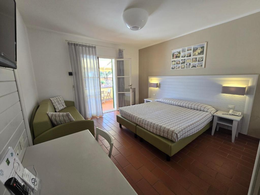 une chambre d'hôtel avec un lit et un canapé dans l'établissement Hotel Mare, à Portoferraio